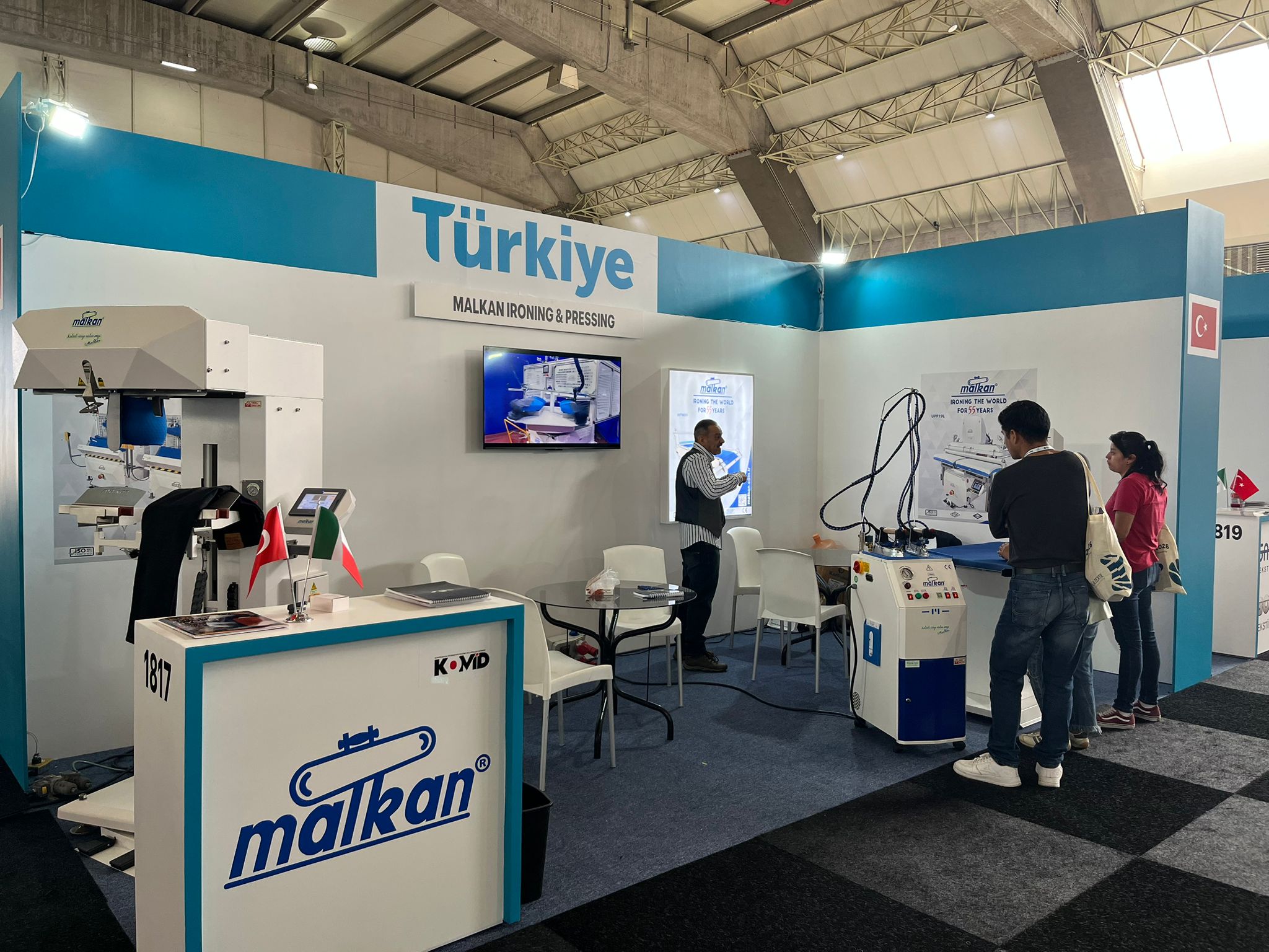 Malkan engineers presenting the fabric analysis capabilities of their latest AI-powered ironing technologies during a live demonstration